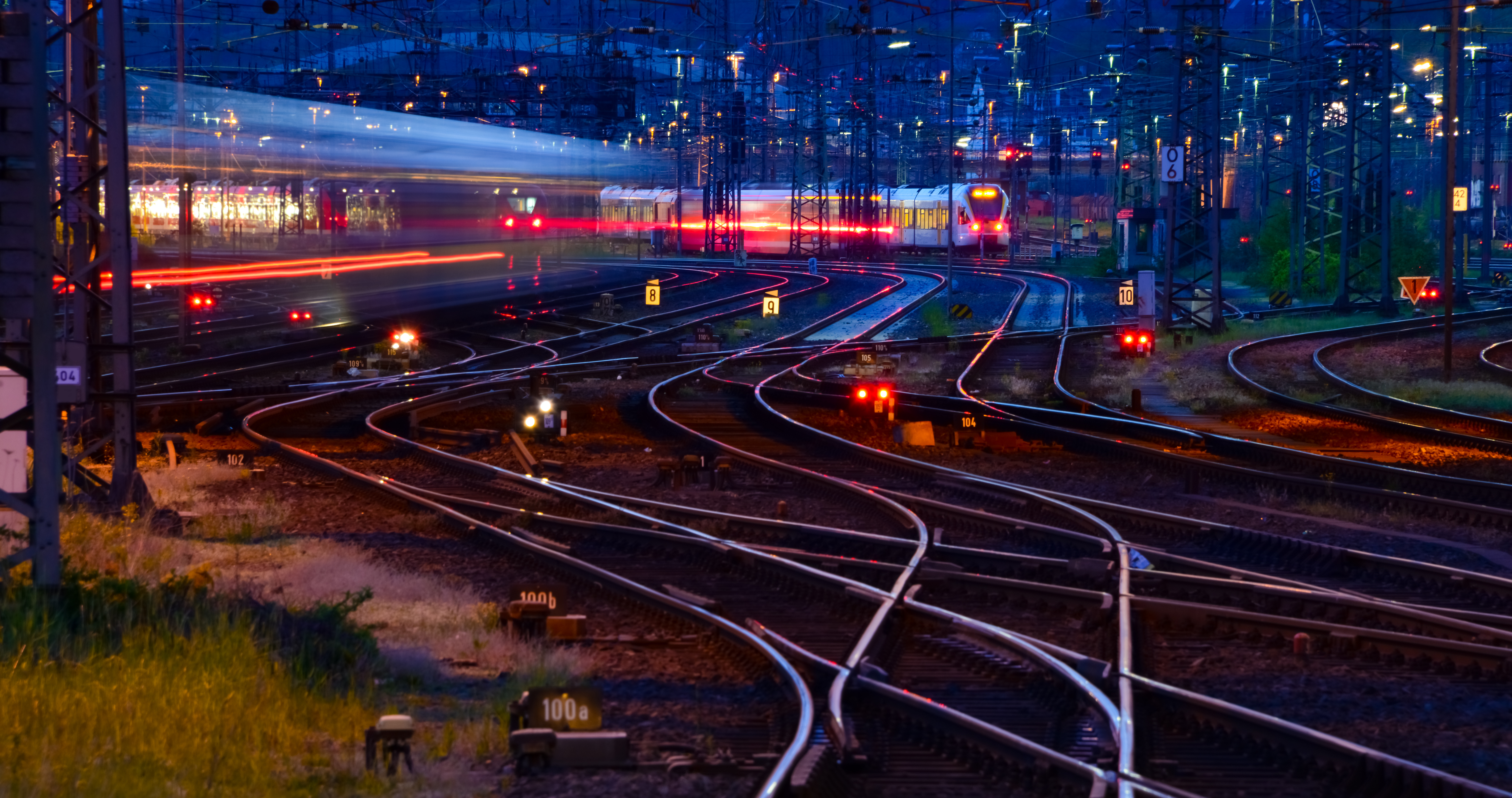 Night-time railway junction with illuminated tracks and signals representing complex rail infrastructure for accredited assessment and certification