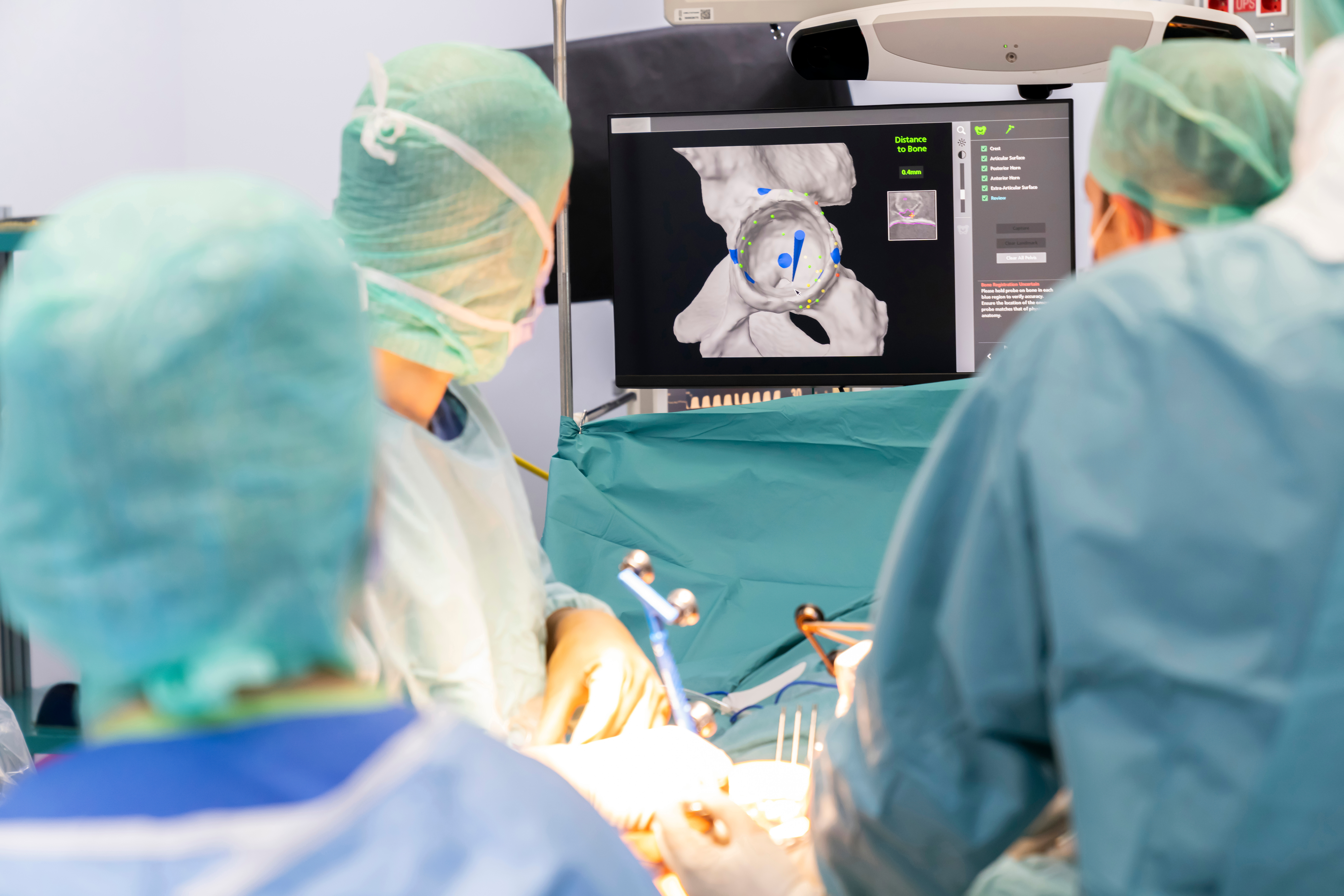 Orthopaedic surgical team reviewing joint replacement imaging in a facility preparing for DNV Advanced Hip & Knee Replacement Certification
