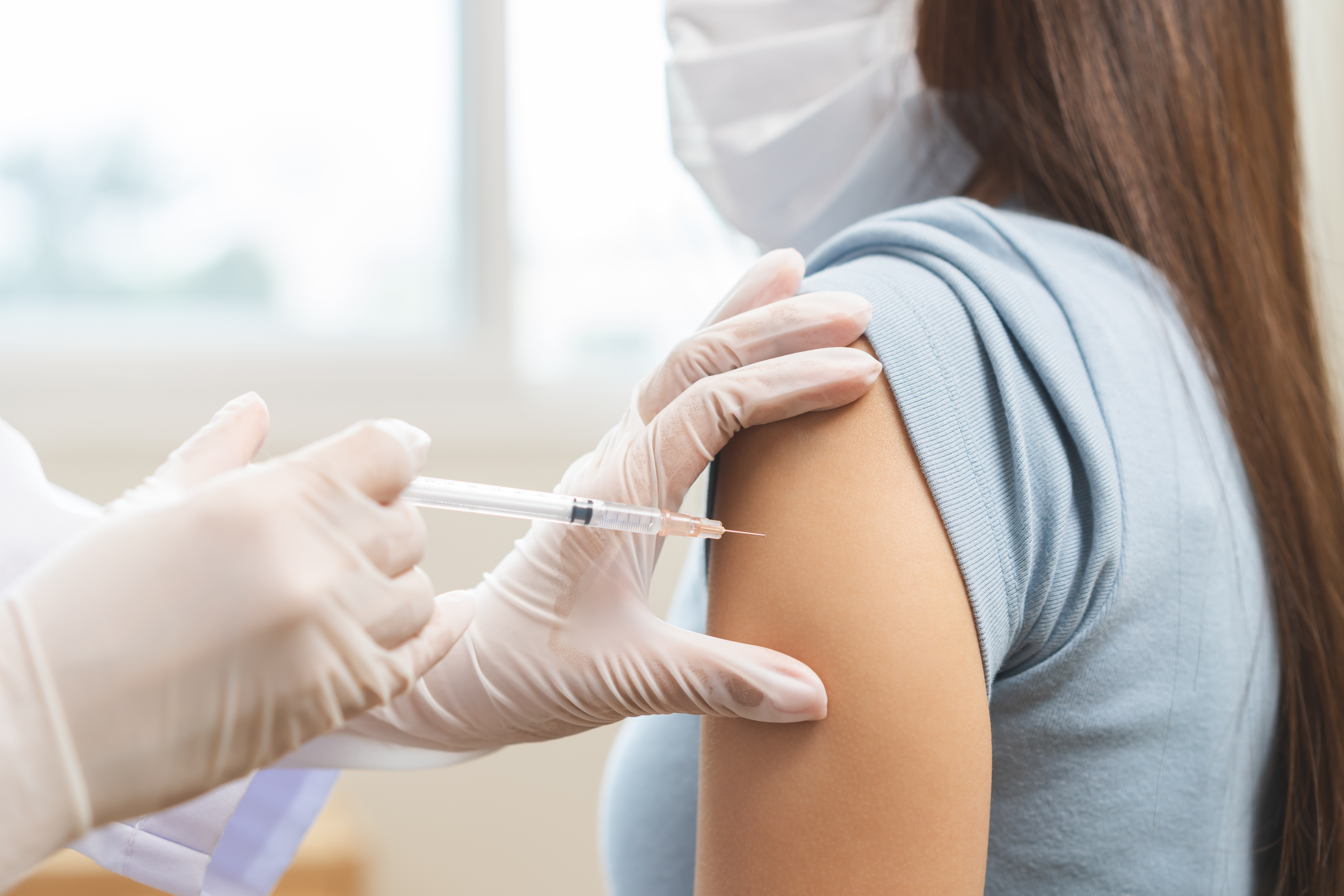 Clinician providing hands-on patient care in a hospital setting, representing evidence-based infection prevention practices aligned with DNV’s AC-IP certification