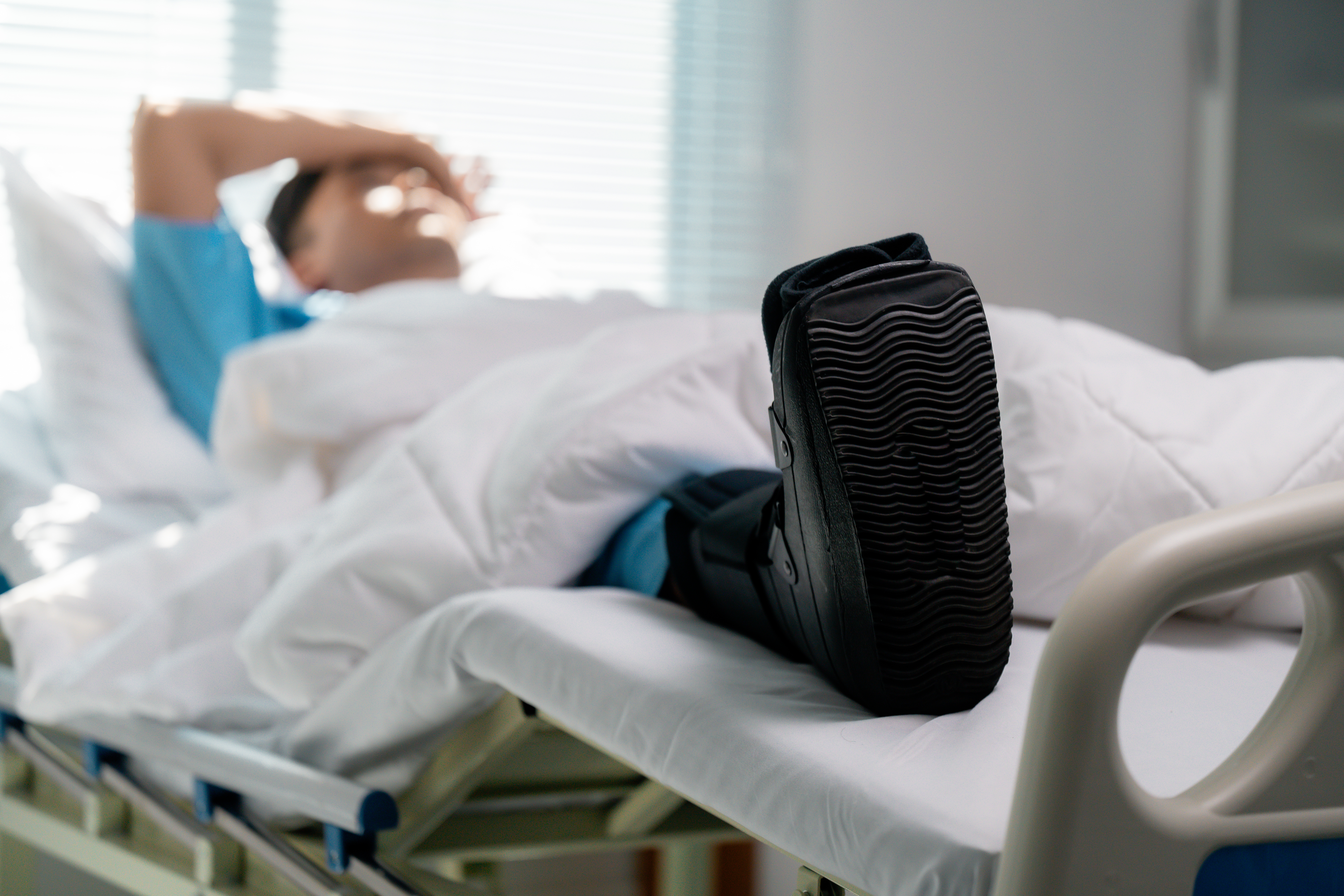 Foot and ankle surgery patient wearing a protective orthopedic boot during recovery, emphasizing safe postoperative care and improved outcomes