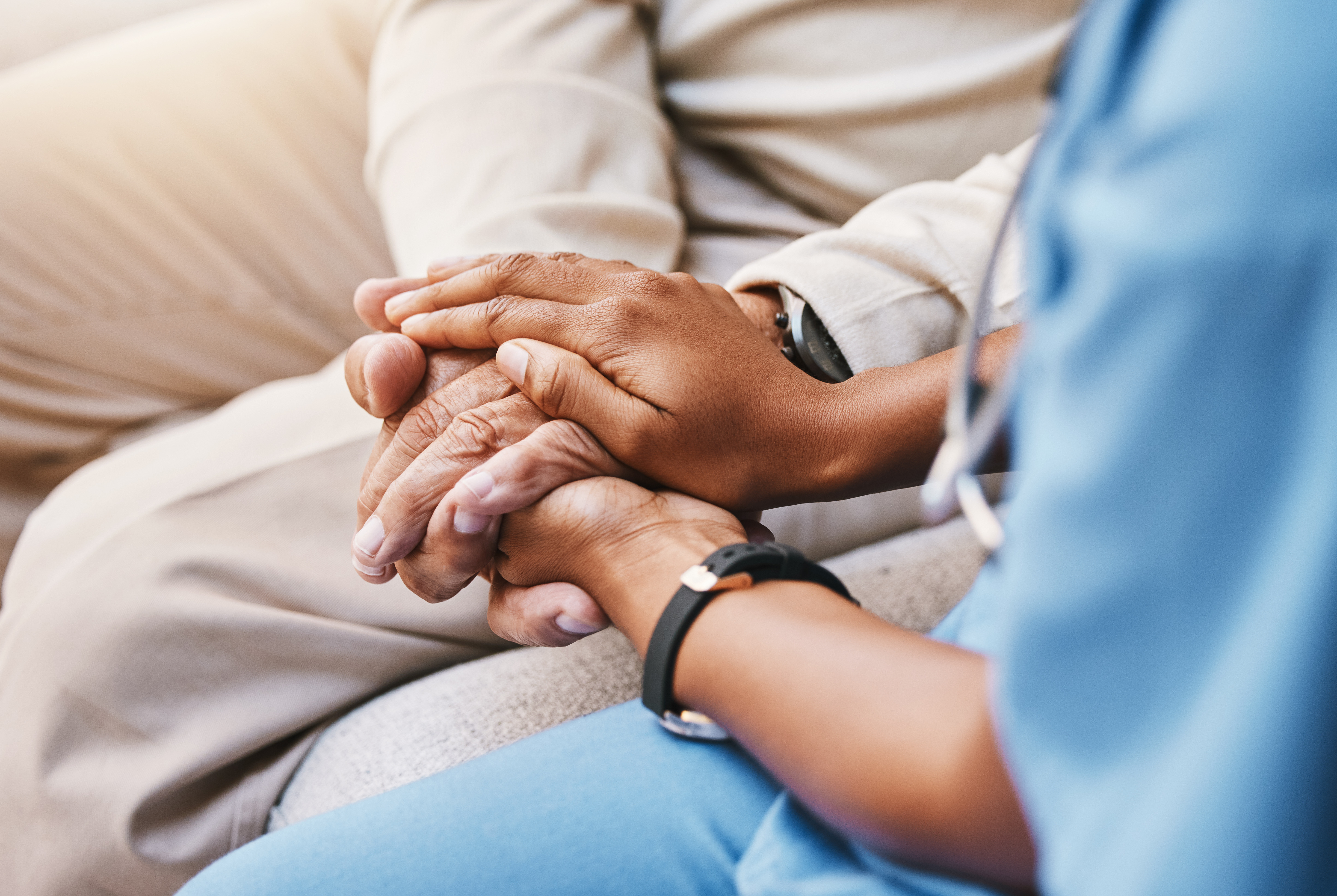 Clinician holding a patient’s hand during stroke care consultation, representing DNV’s trusted experts in advanced stroke centre certification