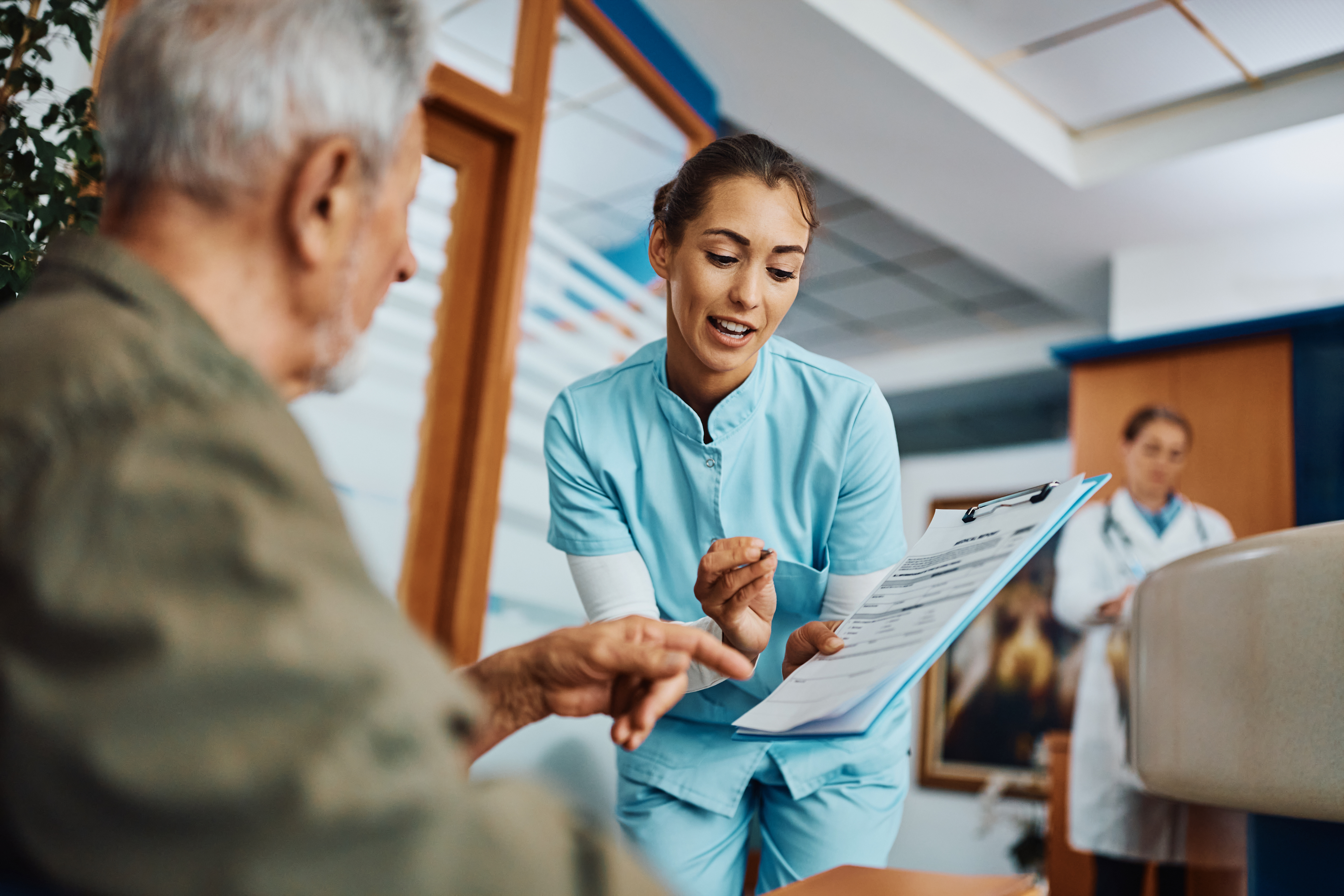 Clinician reviewing medical information with an older patient in an ASC meeting DNV NIAHO® accreditation requirements