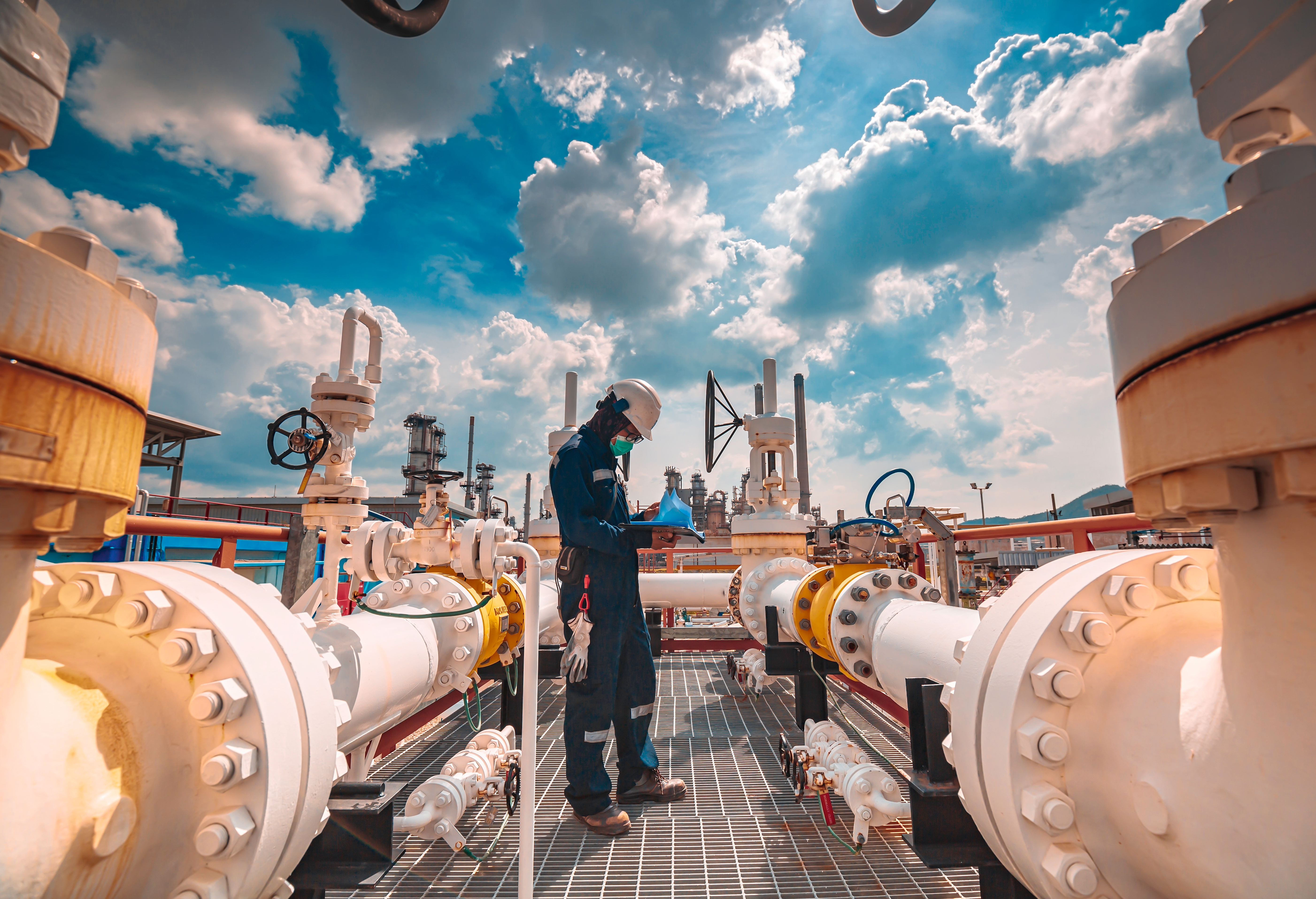 Engineer inspecting large-scale industrial refinery equipment, symbolising carbon credit validation, verification, and decarbonisation in hard-to-abate sectors